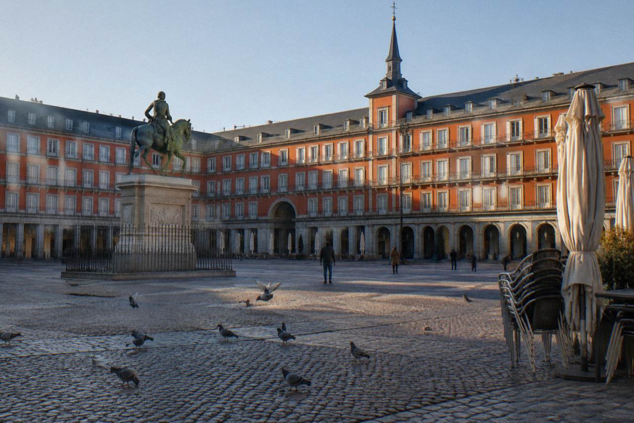 A quiet morning square in old Madrid with historic facades in warm light