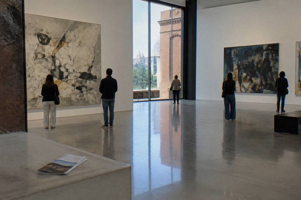 Exhibition gallery interior at CaixaForum Madrid with visitors viewing large artworks