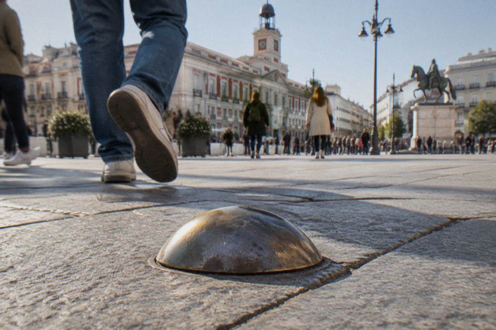 The Kilometer Zero marker in Puerta del Sol beneath the Tio Pepe sign