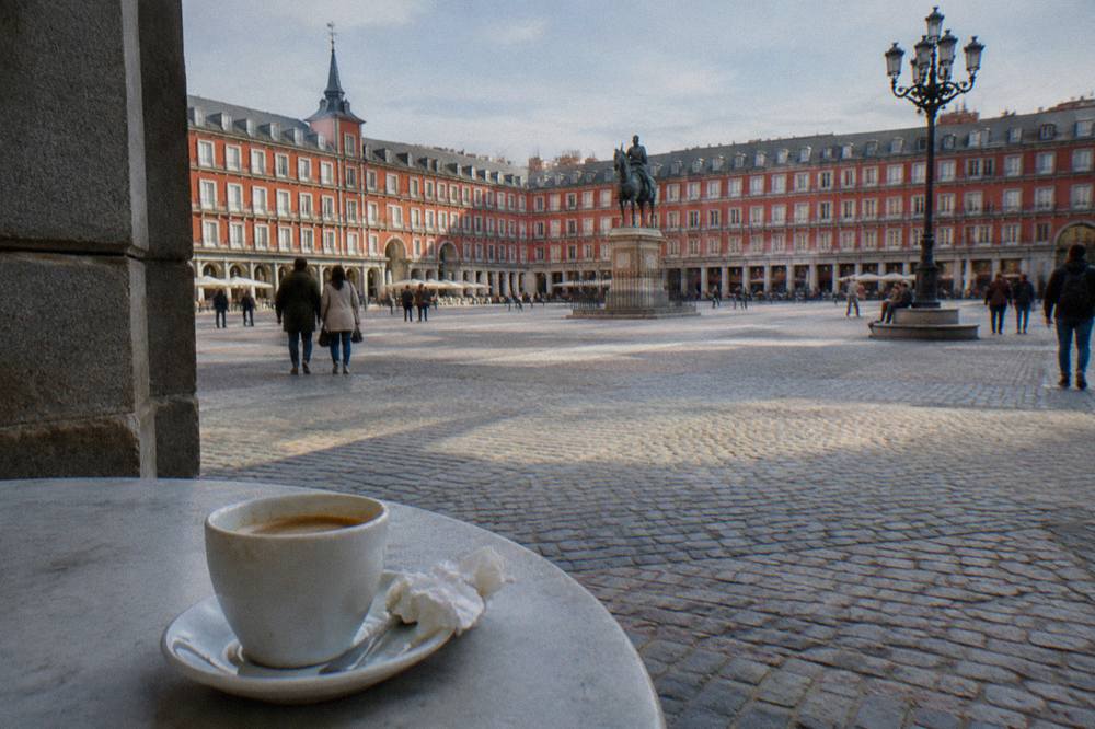 Old Madrid street with cafe tables and painted building facades in the Austrias quarter