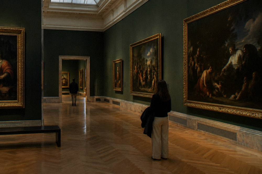 Gallery hall in a Madrid museum with classical paintings along the walls