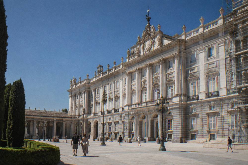 The ornate baroque facade of the Royal Palace of Madrid on a clear morning