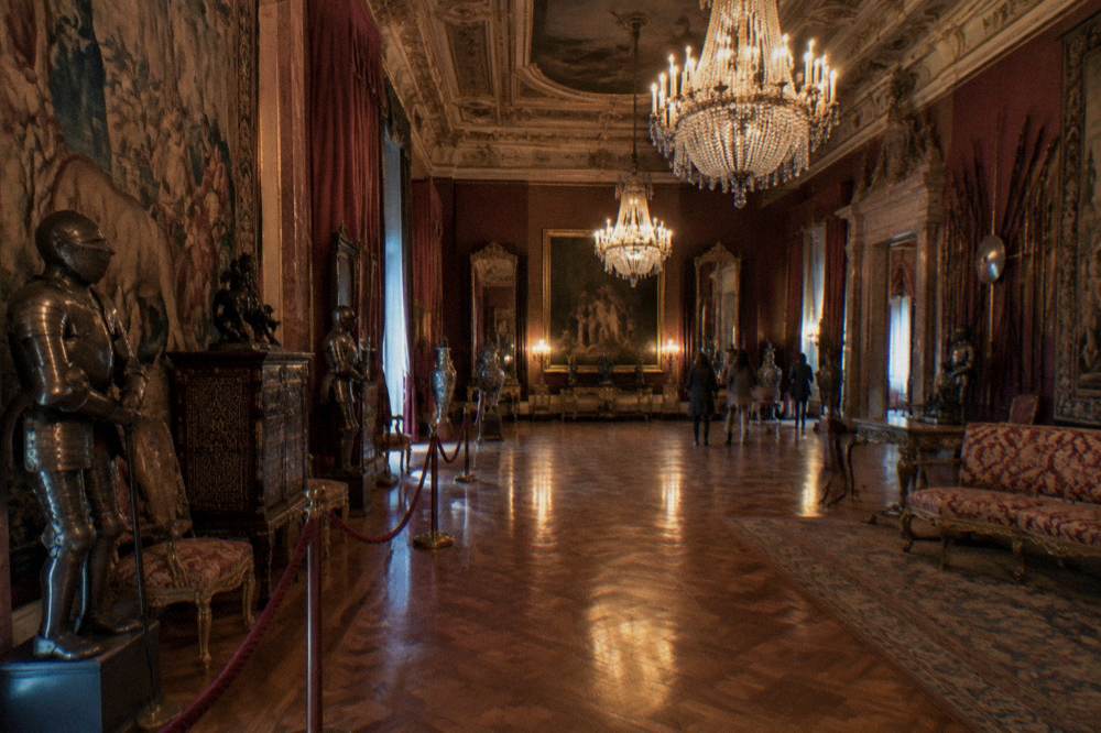 Ornate palace interior with chandeliers, tapestries and gilded ceiling moulding