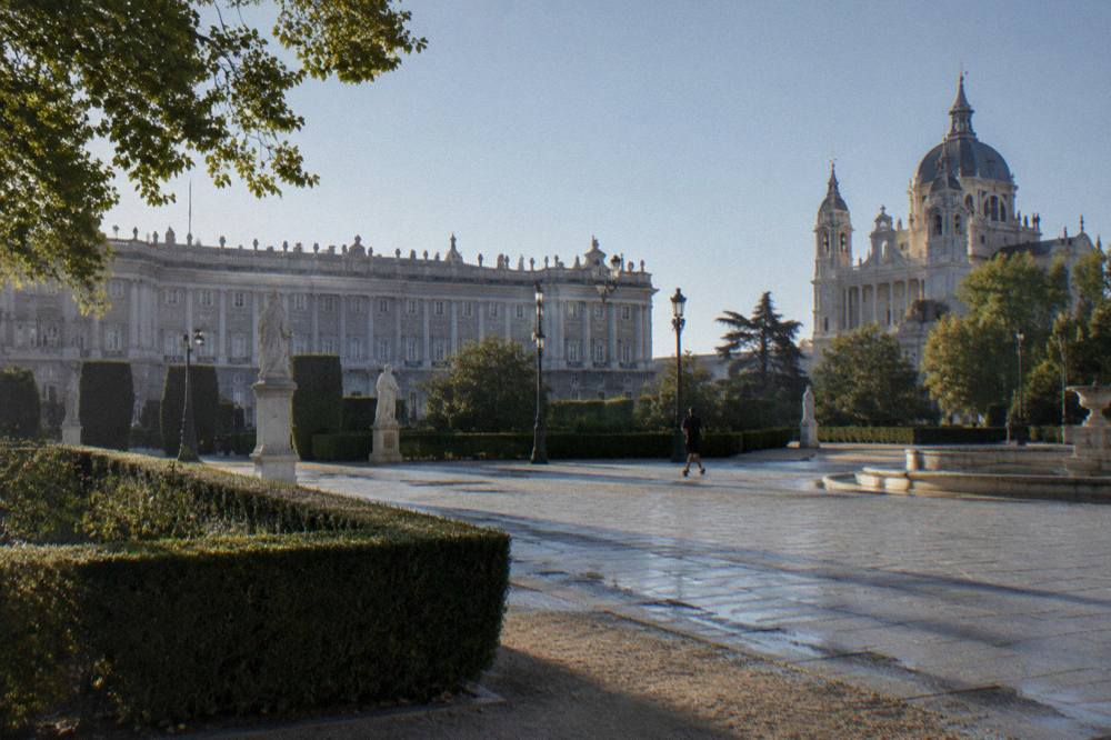 Wide plaza in central Madrid under a clear morning sky with historic buildings on all sides