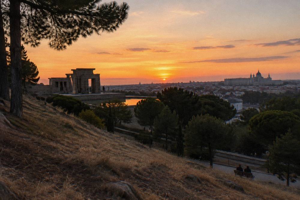 Sunset silhouette of the Templo de Debod with the Royal Palace visible in the distance