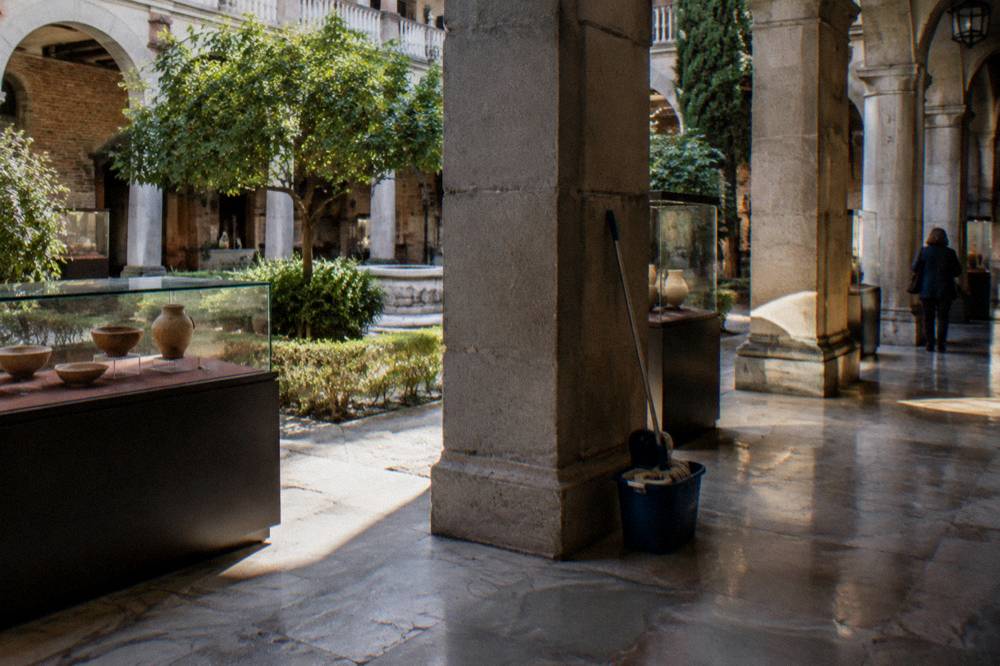 Interior courtyard of a free municipal museum in Madrid with stone arches and display cases