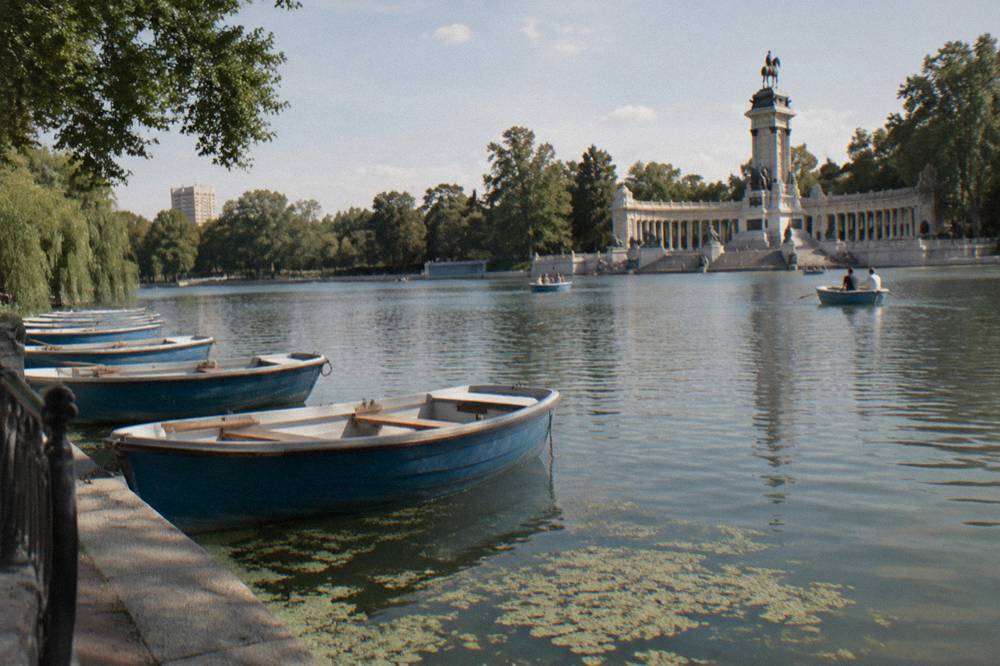 Rowing boats on Retiro Park lake with the monument to Alfonso XII in the background