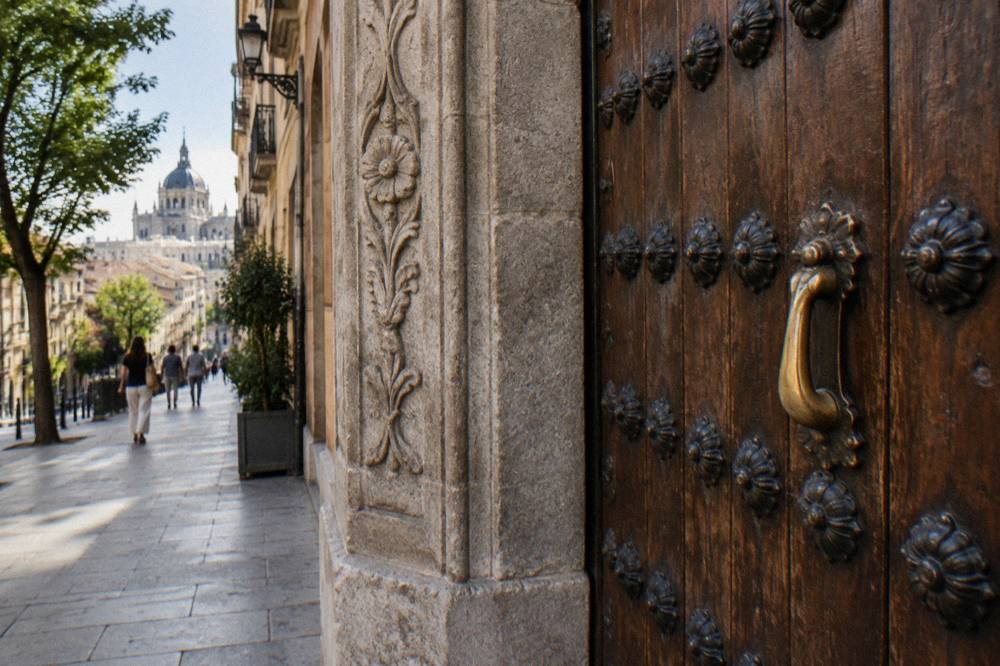 Ornate wooden door of a historic Madrid building with iron studs and carved detail