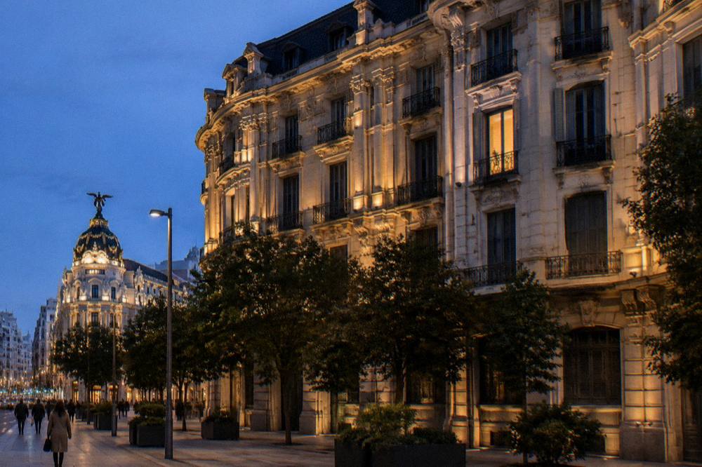 Illuminated historic facade in Madrid at dusk with warm street lighting