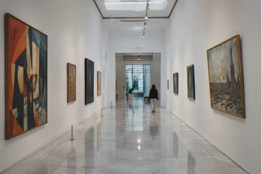 Gallery corridor inside a Madrid art museum with framed paintings along both walls