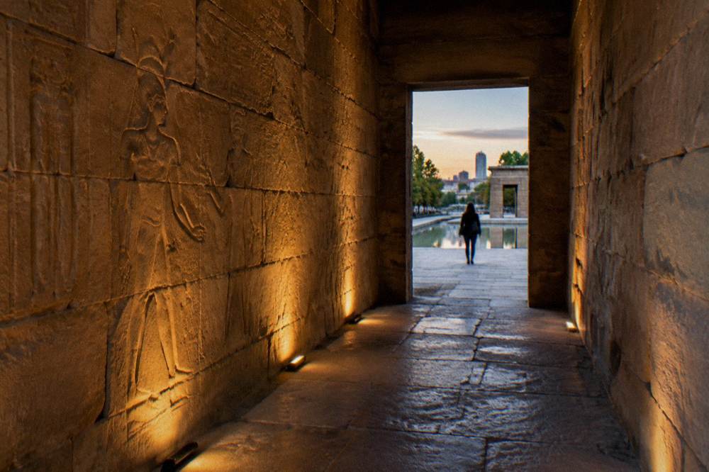 Stone corridor inside an ancient temple with low light and carved walls